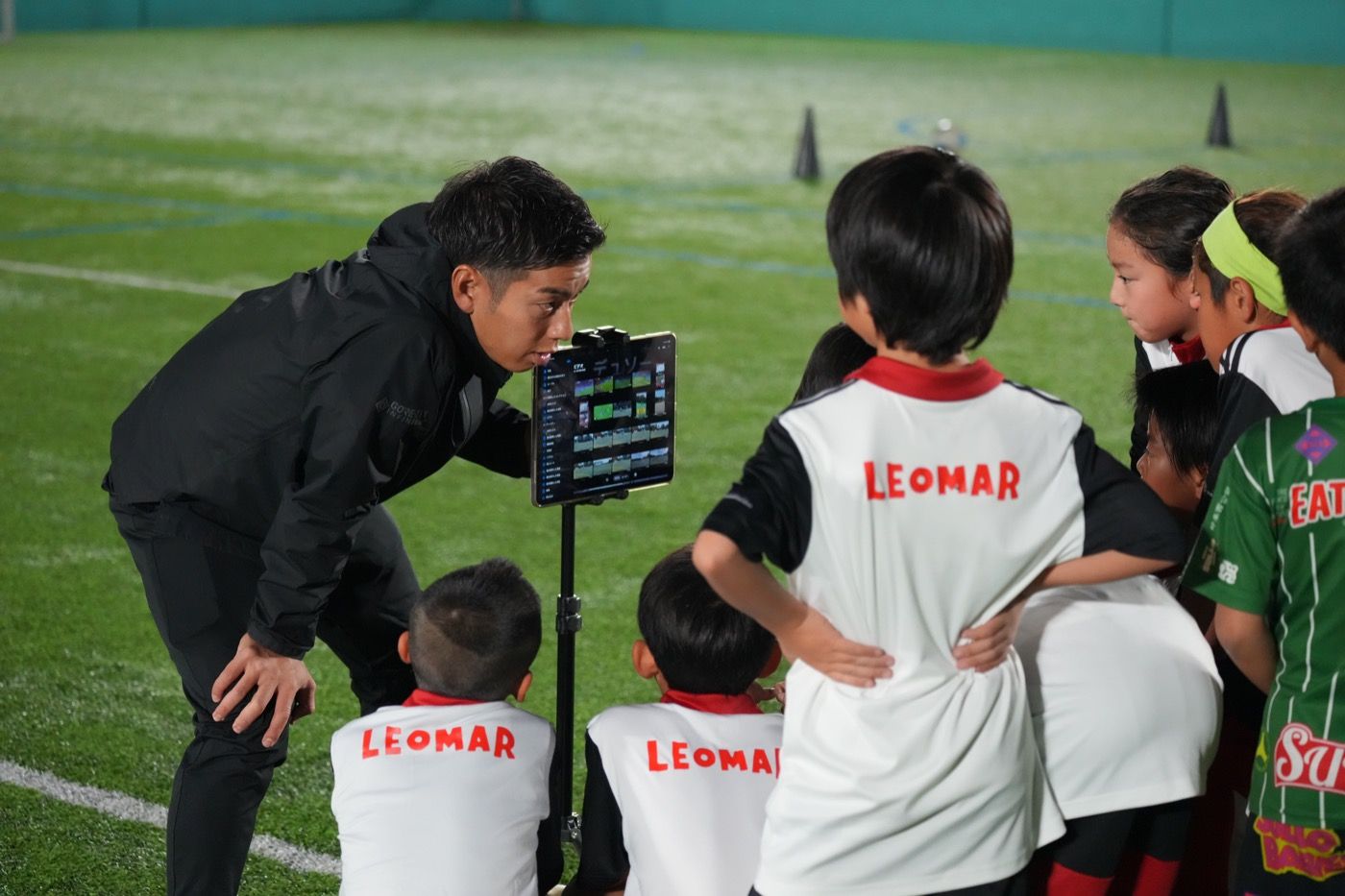 コーチがタブレットで映像を見せながらミーティング（横浜校）